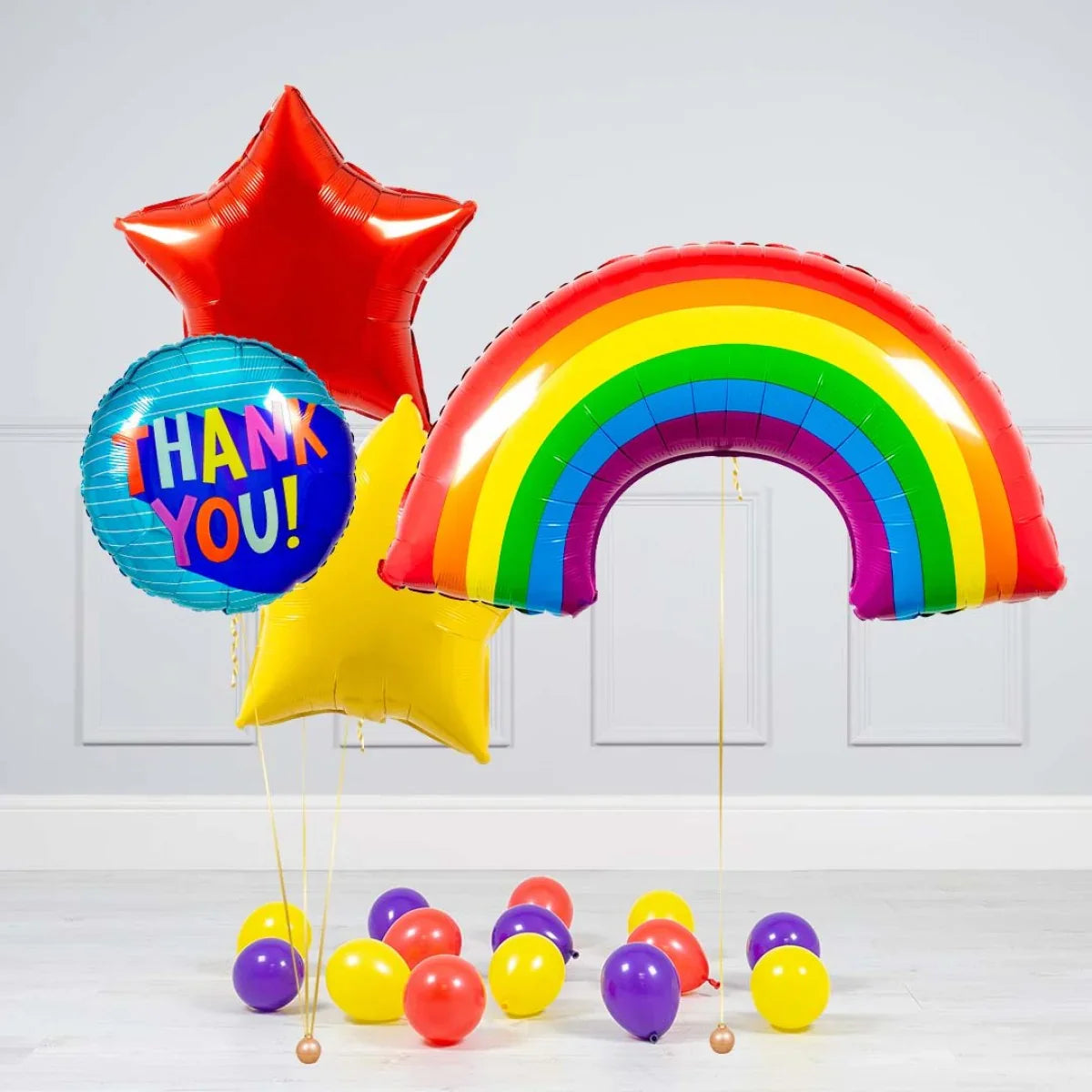 Colorful helium balloons including red and yellow stars, a blue 'Thank You!' balloon, a rainbow-shaped balloon, and small scattered balloons