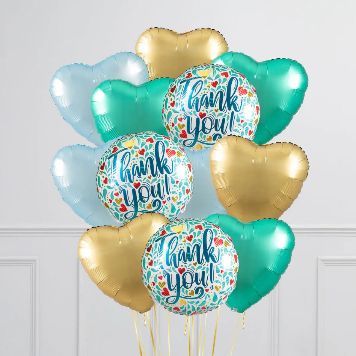 Thank you round balloons with floral hearts design and gold, teal, blue heart-shaped balloons in room