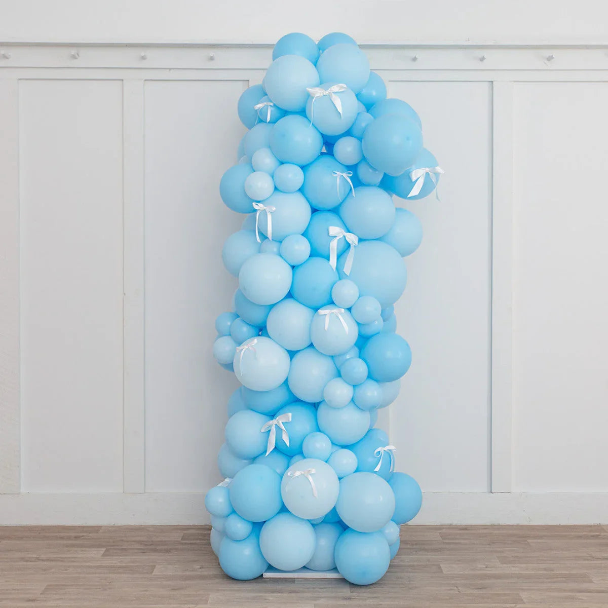 Baby blue balloon pillar with white bows, party decoration in Dubai