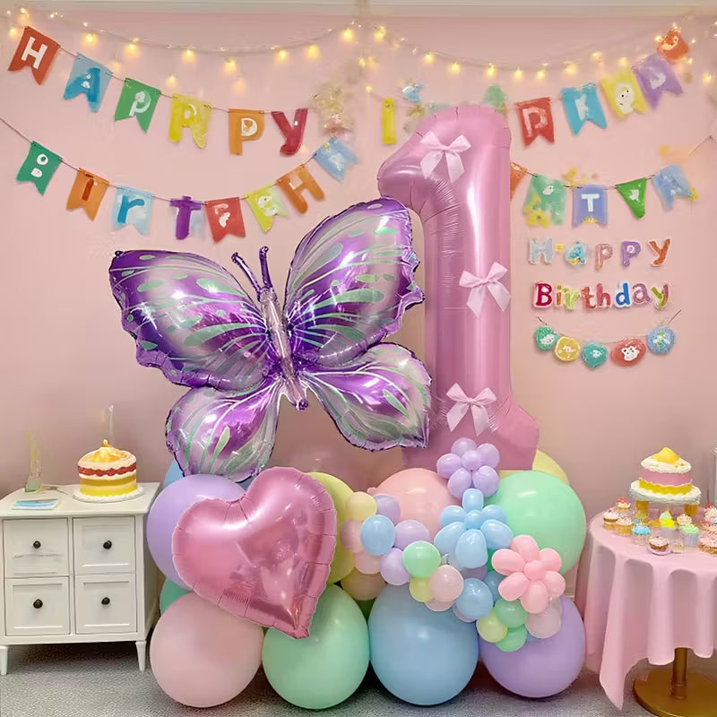 Pink number 1 balloon with purple butterfly and heart-shaped foil balloons in pastel birthday party setup