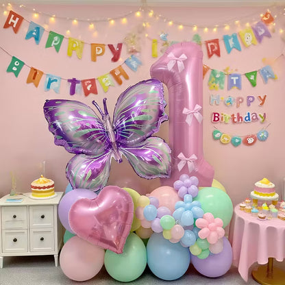 Pink number 1 balloon with purple butterfly and heart-shaped foil balloons in pastel birthday party setup
