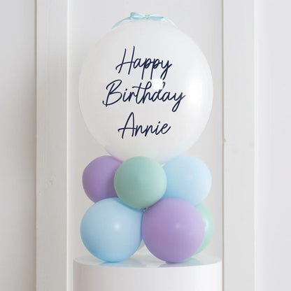Personalized white happy birthday bubble balloon with pastel purple, blue, and green balloons stack