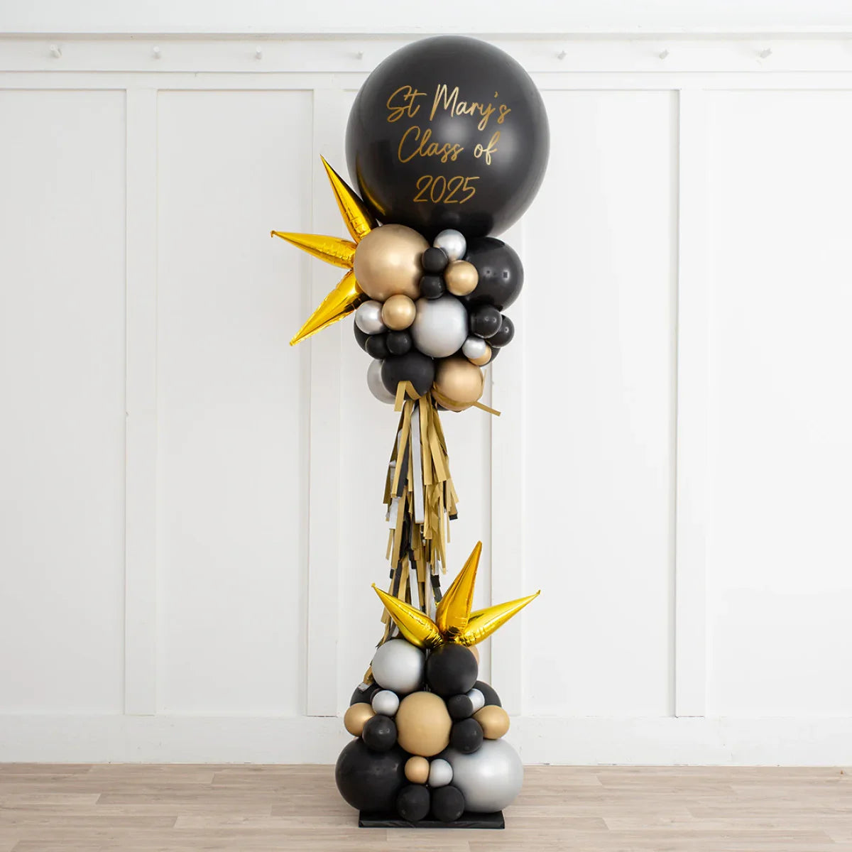 Tall balloon arrangement in black, gold, and silver with text St Mary's Class of 2025 for graduation party