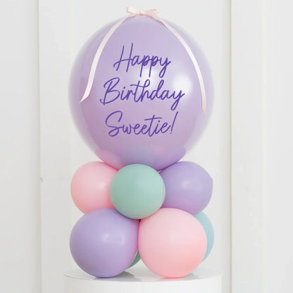 Personalised pastel balloon stack with 'Happy Birthday Sweetie!' message on lavender air-filled bubble balloon