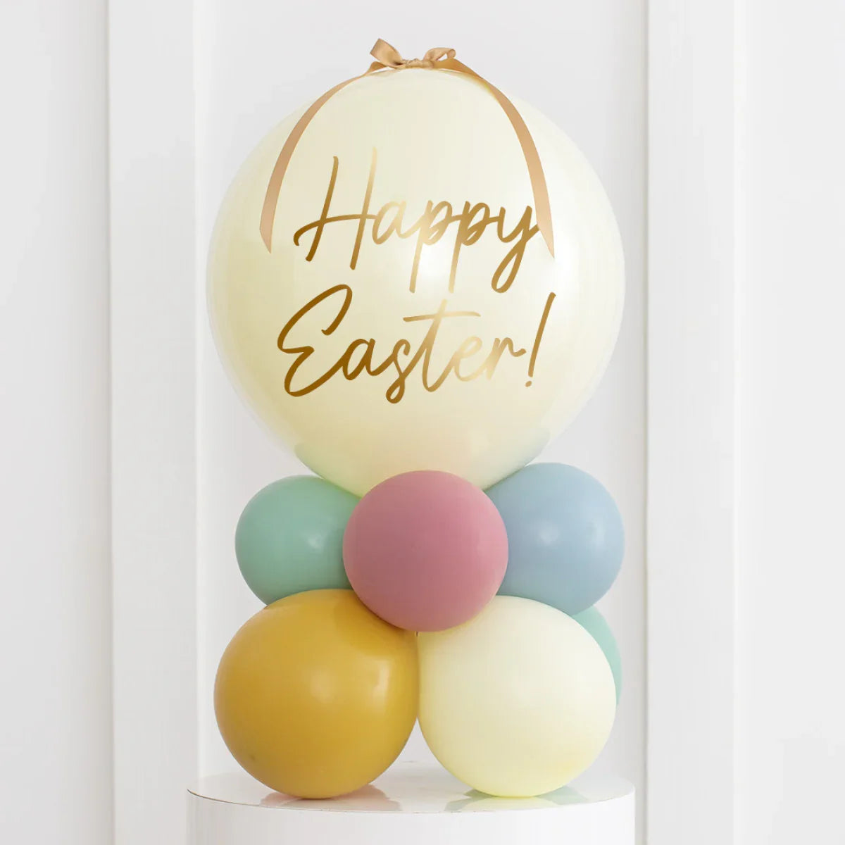Pastel Easter balloon arrangement with large cream bubble and gold Happy Easter text