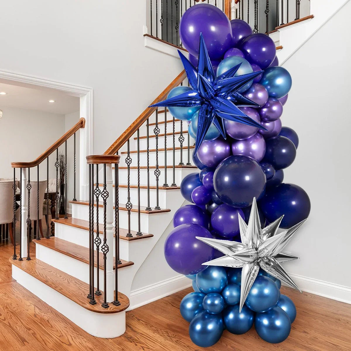 Cluster of blue and purple balloons with metallic star balloons decorating indoor wooden staircase