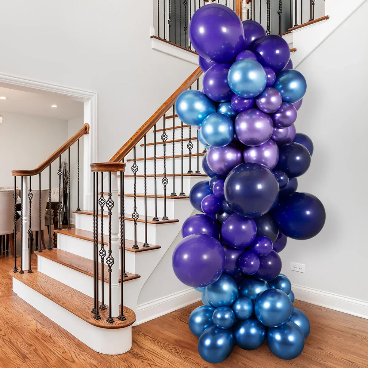 Inflated balloon pillar with purple and blue metallic balloons decorating wooden staircase in modern home