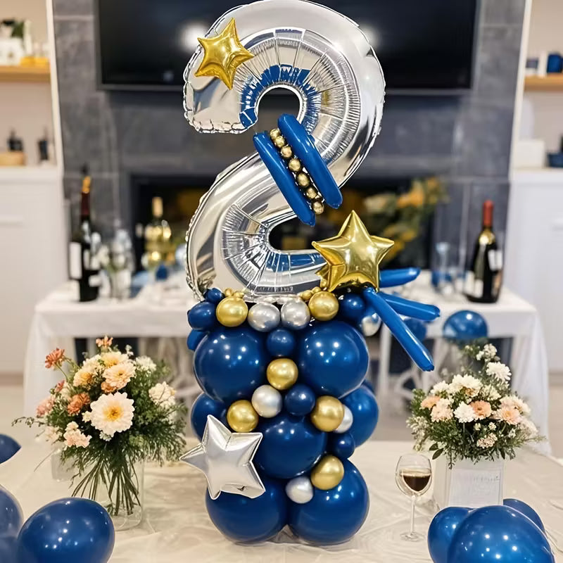 Silver number 2 balloon centerpiece with blue, gold, and silver balloons and star-shaped accents on party table