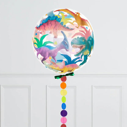 Clear balloon with colorful dinosaur illustrations and rainbow ribbon against white wall