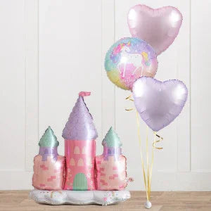 Pink and purple castle balloon with pastel unicorn and heart-shaped balloons on wooden floor